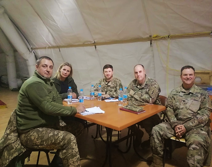 A group of people in military uniforms sitting at a table

AI-generated content may be incorrect.